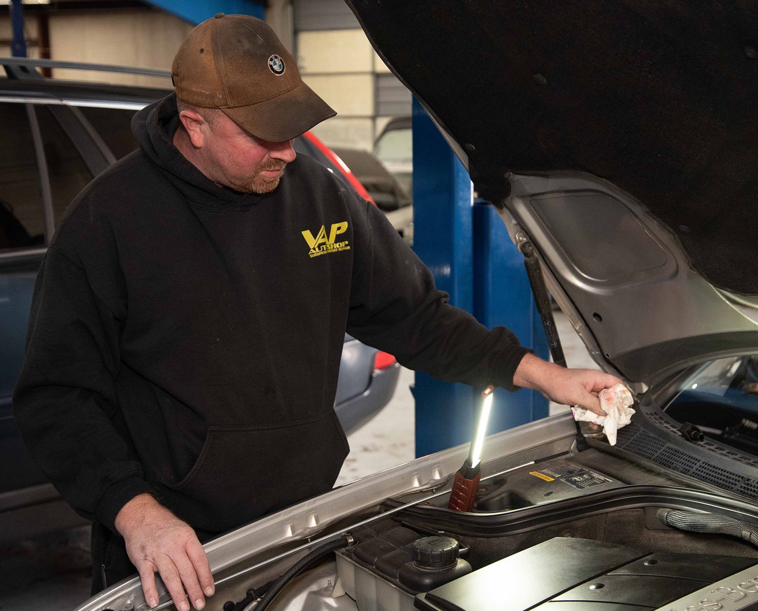 VAP Auto Shop technician working under an open vehicle hood