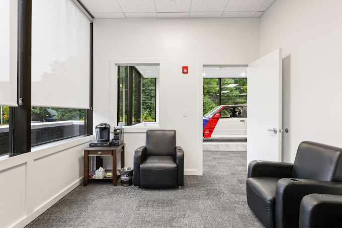 Waiting area with armchairs and a coffee station.