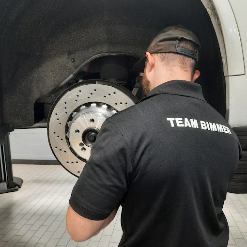 Technician working beside an exposed brake rotor.